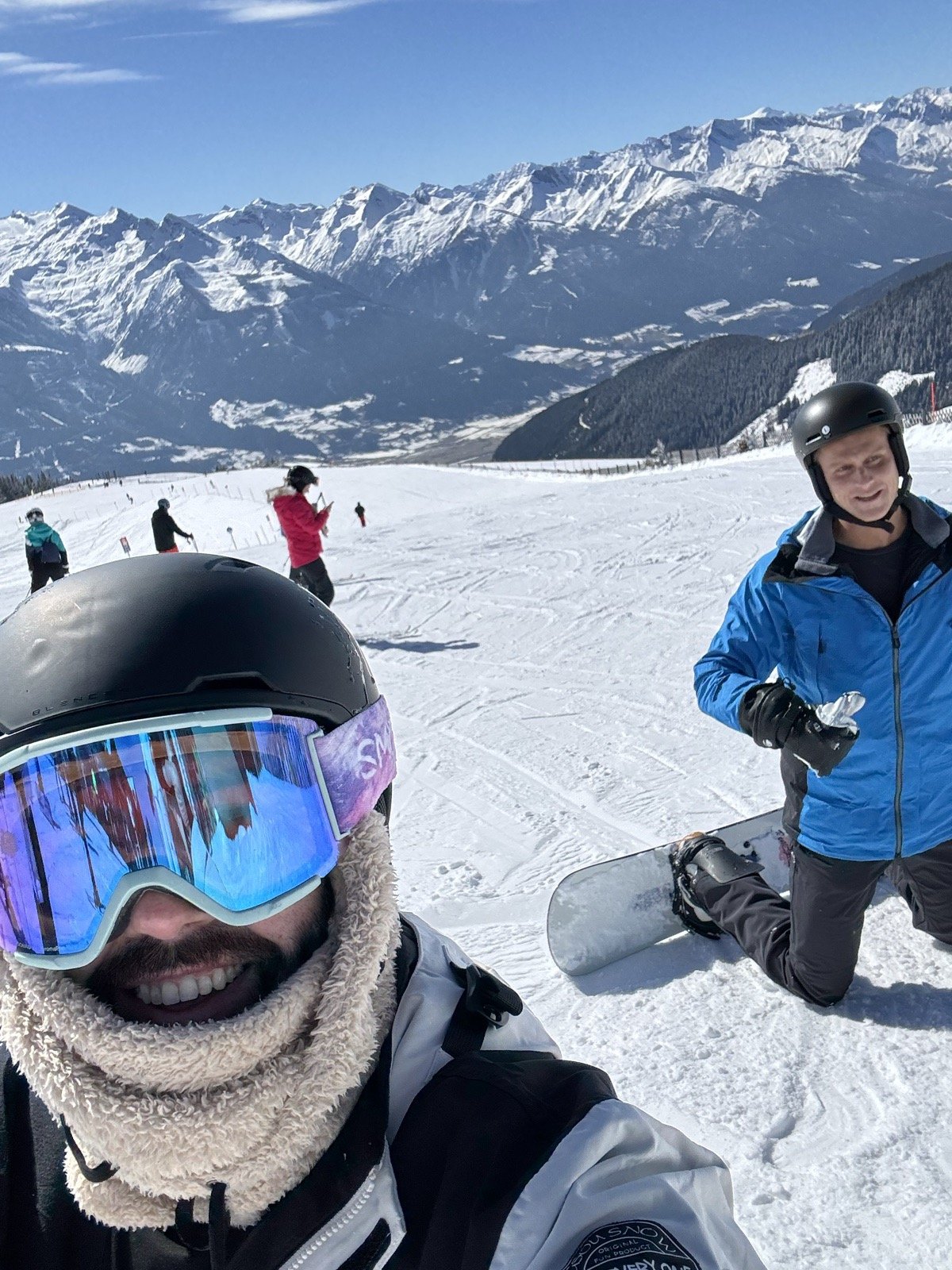 Michael up close and Andrew kneeling with his board, the valley wide open behind them